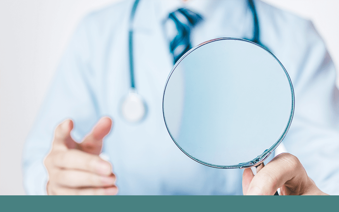 Photo of a doctor holding a magnifying glass. Photo d'un médecin tenant une loupe.