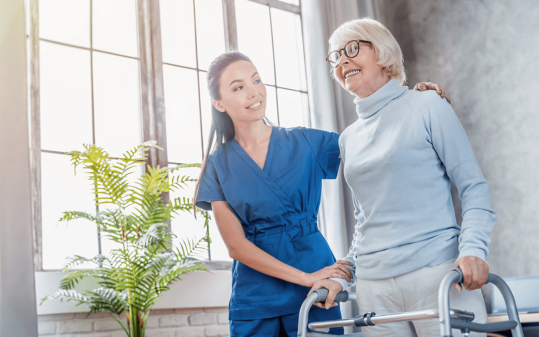 Photo of woman in scrubs helping an elderly female using a walker. Photo d'une femme en blouse aidant une femme âgée à l'aide d'une marchette.